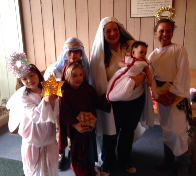 Costumed children with mother and baby gather in meetinghouse lobby