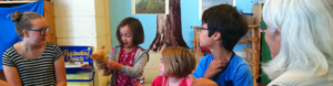 Children and adults play a singing game with a puppet during Sunday School at Berkeley Friends Church