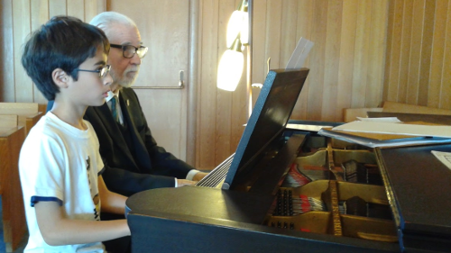 A young and an old musician at the keyboard